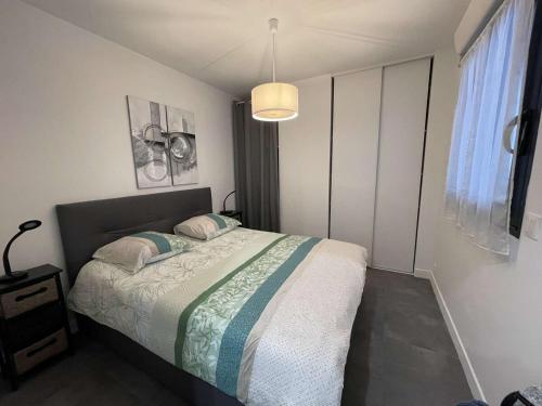 - une chambre avec un lit et une lampe pendant dans l'établissement Apartment in Porto-Vecchio with pool, à Porto-Vecchio