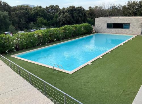 - une piscine dans une cour avec une pelouse verdoyante dans l'établissement Apartment in Porto-Vecchio with pool, à Porto-Vecchio