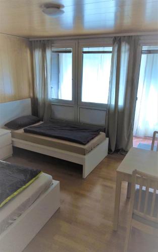 a bedroom with two beds and two windows at Monteurwohnung 5 Hoffmann in Heilbronn
