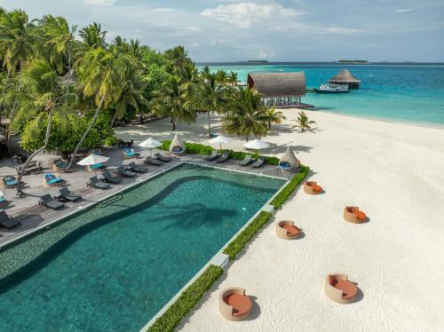 an aerial view of a resort swimming pool and the beach at Angsana Velavaru In-Ocean Villas in Dhaalu Atoll