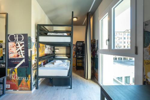 a room with bunk beds and a window at a&o Hostel Firenze Campo di Marte in Florence