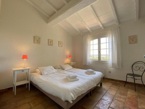 une chambre avec un grand lit blanc avec une fenêtre dans l'établissement Très belle villa vue mer - Piscine à débordement, à La Croix-Valmer