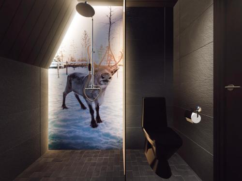 a bathroom with a painting of a deer in the snow at Aurora Village Ivalo in Ivalo