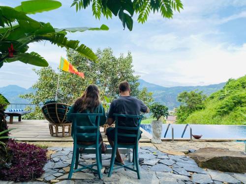 a man and woman sitting at a table looking out at the mountains at Awesome Place in Ella
