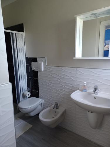 a white bathroom with a sink and a toilet at B&B Casa Dany in Ricadi