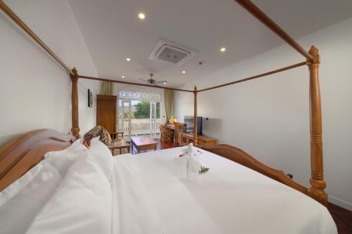 a bedroom with a large bed with white sheets at Lanna Inthan Resort in Doi Saket