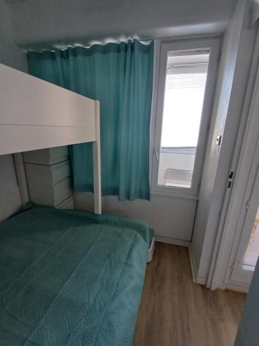une petite chambre avec un lit et une fenêtre dans l'établissement Le nid des hirondelles, à Leucate-Plage