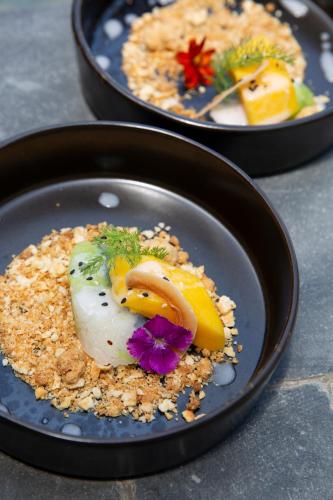 two plates of food on a table at Clay Beach Samui - Beachfront Villas in Amphoe Koh Samui