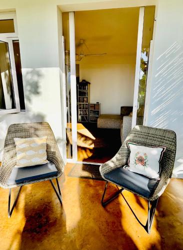 two chairs with pillows in a living room at Lakaz Kreol Soupir Tourist Résidence in Rodrigues Island