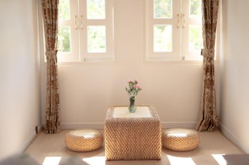 a vase sitting on a table in a room with two windows at Lanna Inthan Resort in Doi Saket