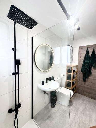 a bathroom with a sink and a toilet and a mirror at Atreb San Fernando in San Fernando