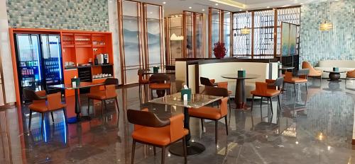 a restaurant with orange chairs and tables in a room at Hotel Anda China Malabo in Malabo