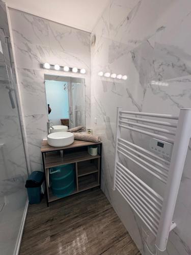 une salle de bain blanche avec un lavabo et un miroir dans l'établissement Super T3 Résidence Piscine, à Sainte-Maxime