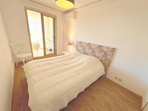 un grand lit dans une chambre avec une fenêtre dans l'établissement Super T3 Résidence Piscine, à Sainte-Maxime