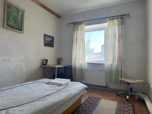 a bedroom with a bed and a window at Gana's Guest House and Tours in Ulaanbaatar