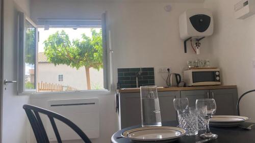 a kitchen with a table with glasses on it at Petite pause à la Viarhona in Condrieu