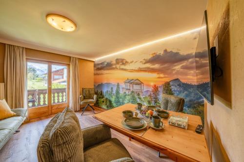a living room with a large painting on the wall at Gästehaus Alpina in Krün