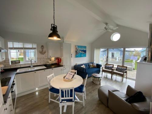 a kitchen and living room with a table and chairs at Seafolly Beach House The Bay Filey Step Free Accommodation Private Offstreet Parking in Filey