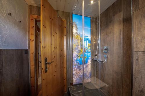 a bathroom with a shower with a glass door at Gästehaus Alpina in Krün