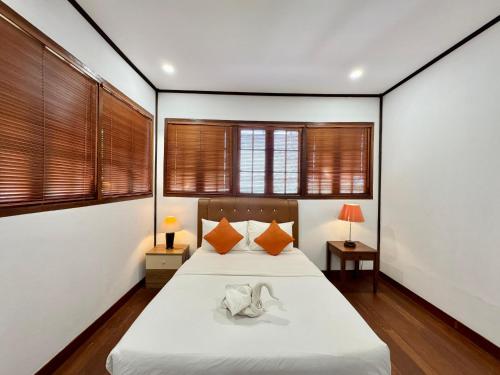 a bedroom with a bed and two windows at Nongsa Village in Nongsa