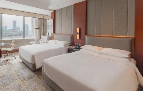 a hotel room with two beds and a window at Shanghai Marriott Marquis City Centre in Shanghai