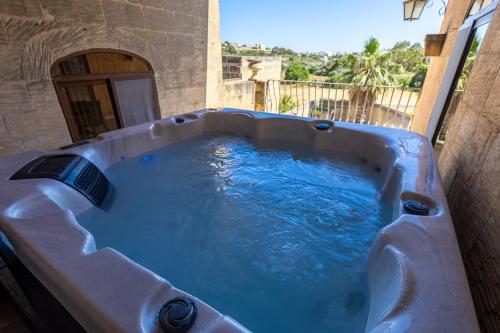 a jacuzzi tub with blue water in it at Centre Island Holiday Home with private pool and hot tub in Kerċem