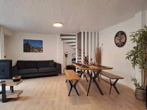 un salon avec une table et un canapé dans l'établissement Au Bon Endroit, à Aiguilhe