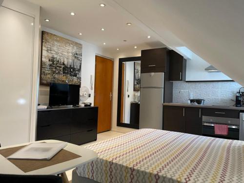 Cet appartement comprend une chambre avec un lit, une table et une cuisine. dans l'établissement Nice Studio near city center & Lake, à Annecy