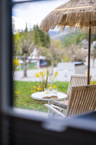 a table with two glasses and an umbrella at Chasa Valambrun 1001 in Vulpera