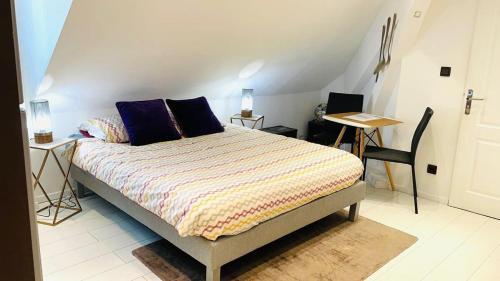 - une chambre avec un lit doté d'oreillers violets et d'une table dans l'établissement Nice Studio near city center & Lake, à Annecy