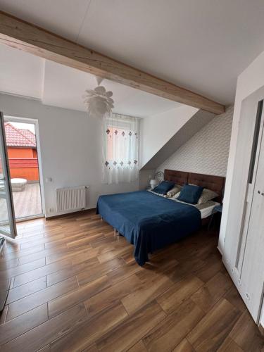 a bedroom with a blue bed and a wooden floor at Pensjonat E&M in Mikołajki