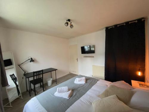 a bedroom with a large bed and a desk at La petite maison du FA in Hillion