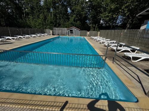 une piscine avec des chaises longues et une piscine dans l'établissement Camping les sablons, à Vergeroux