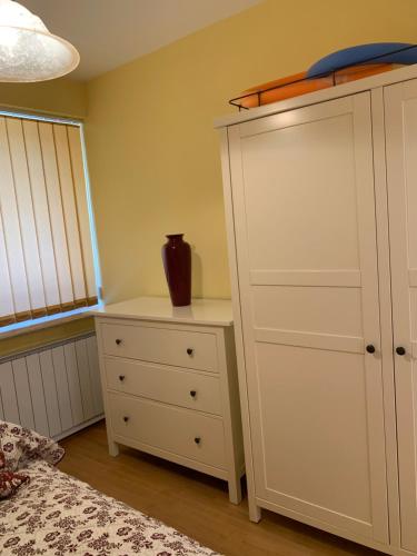 a bedroom with a white cabinet and a dresser at Heviz Gracia Apartment in Hévíz