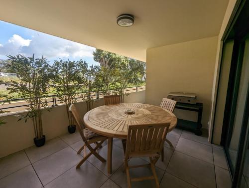 une salle à manger avec une table et des chaises sur un balcon dans l'établissement Appartement neuf près du port de Porto Vecchio, à Porto-Vecchio