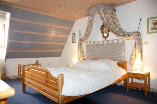 - une chambre avec un lit à baldaquin en bois dans l'établissement Les gîtes d'Auriac, à Calès