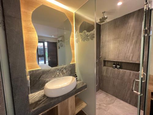 a bathroom with a sink and a mirror at Shinta Guesthouse in Malang