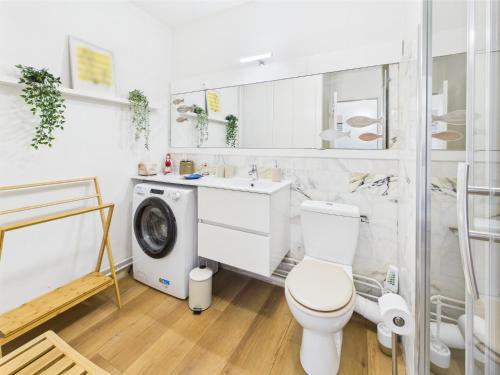 a bathroom with a toilet and a washing machine at -Ocean- Studio renove avec parking et vue mer in Concarneau