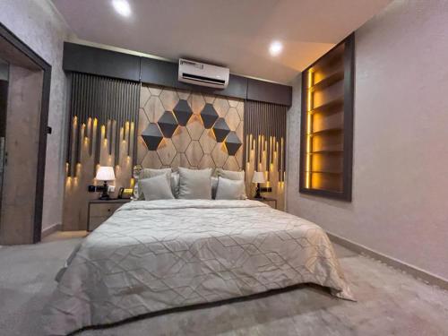 a bedroom with a large bed and a wall at Ridge Apartments in Kano