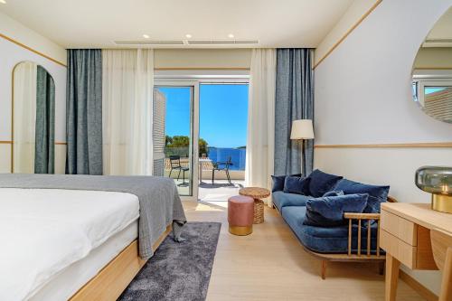 een slaapkamer met een bed, een bank en een raam bij Villa Crystalsea 1 & 2 infinity heatedpool seaview in Hvar