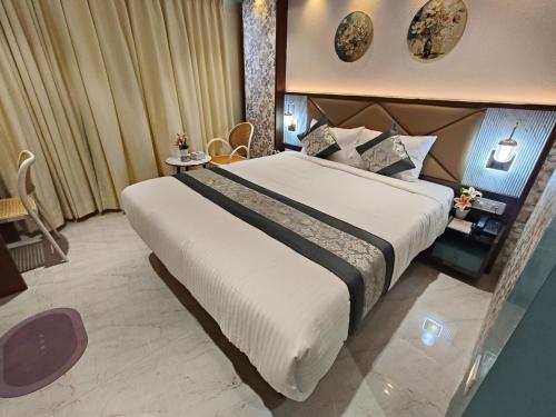 a hotel room with a large bed in it at Hotel Manthan Stays - Airoli in Navi Mumbai