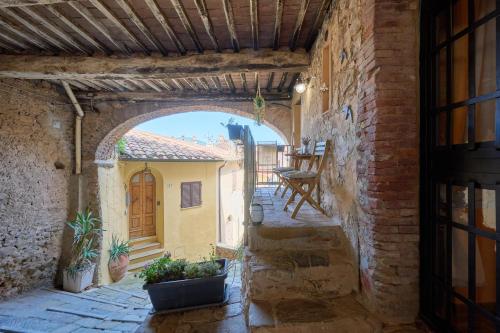 an alley with an archway in a building with a patio at casa Rugiada in Campiglia Marittima