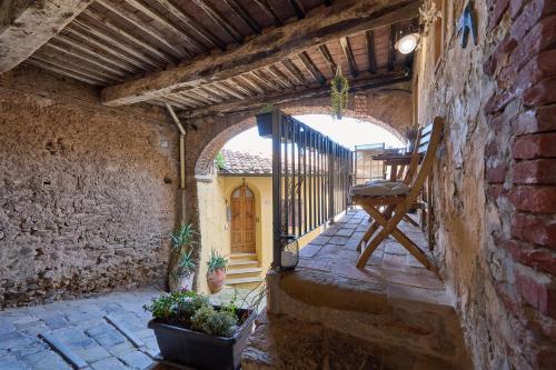 an outdoor patio with an archway in a stone building at casa Rugiada in Campiglia Marittima