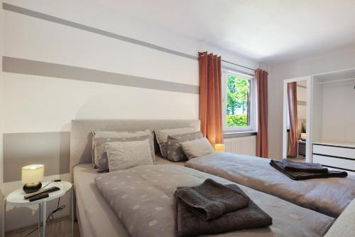 a white bedroom with two beds and a window at Ferienwohnung Wilma Spetzerfehn in Großefehn 