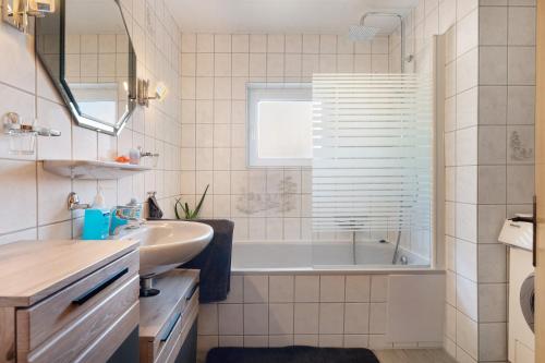 a bathroom with a tub and a sink at Ferienwohnung Wilma Spetzerfehn in Großefehn 