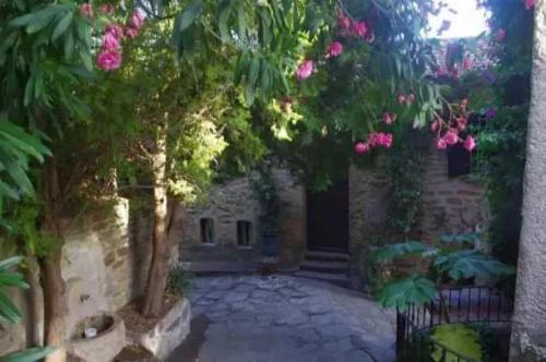 an entrance to a stone building with pink flowers at Appartement 4 étoiles - Parc aquatique - ccaa0ai in Bormes-les-Mimosas