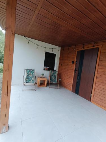 a screened in porch with two chairs and a television at Dom wśród łąk in Suwałki