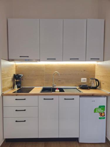 a kitchen with white cabinets and a sink at Star Room's in Durrës