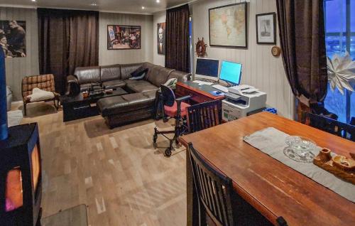a living room with a couch and a desk with a computer at Beautiful Home In Berlevåg With Sauna in Berlevåg