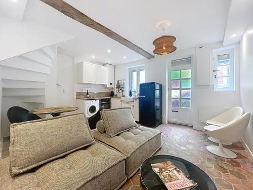 a living room with a couch and a kitchen at Jolie maison Trouville sur Mer in Trouville-sur-Mer